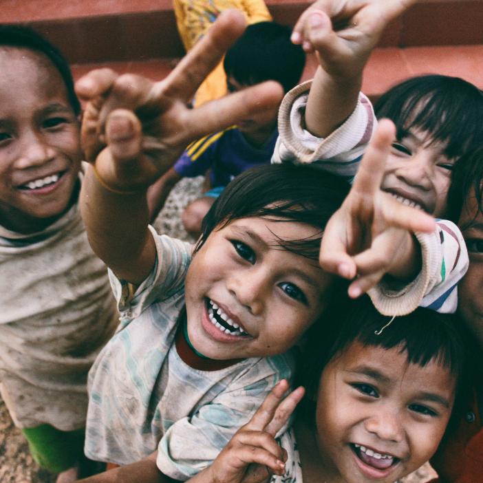 children smiling showing peace sign