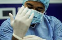 medical professional putting on gloves